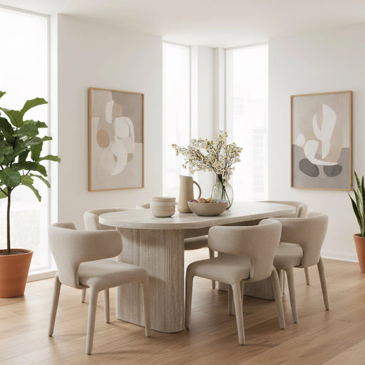 Dining room with a round table and chairs, plants, and abstract art on a white wall.